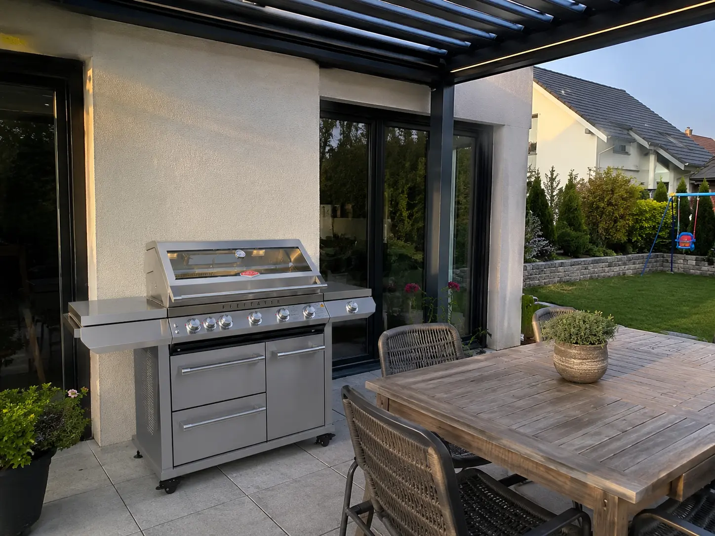 BeefEater 7000 Premium Grillwagen unter einer Pergola am Abend