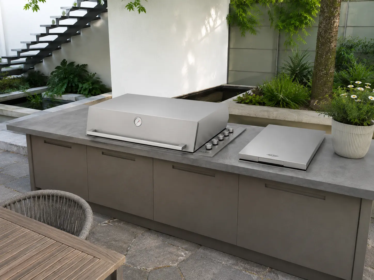 Edelstahl-Einbaugrill von BeefEater in einer Outdoor-Küche mit Betonarbeitsplatte in einem Innenhof